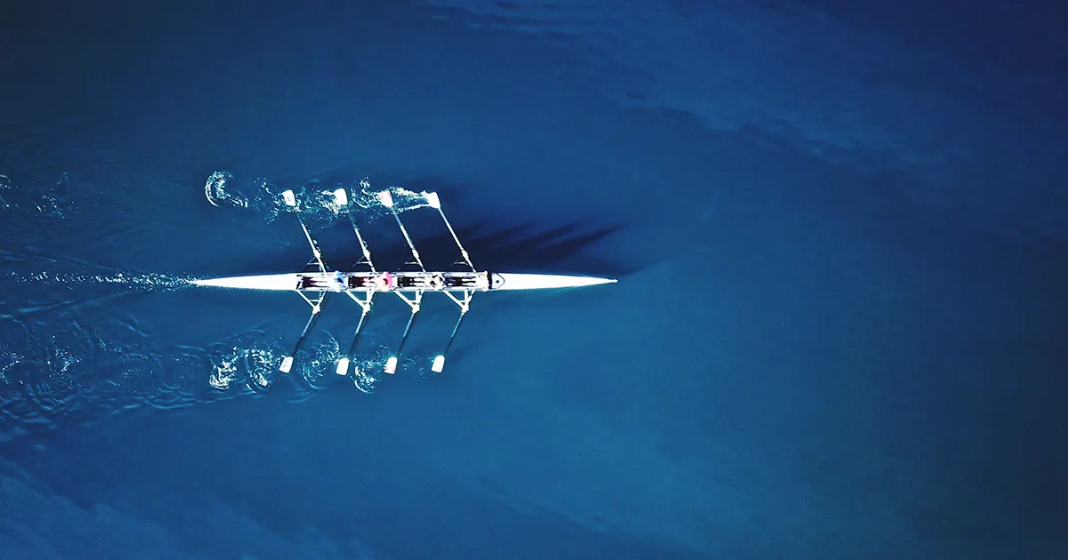 4-man racing boat being rowed on the water