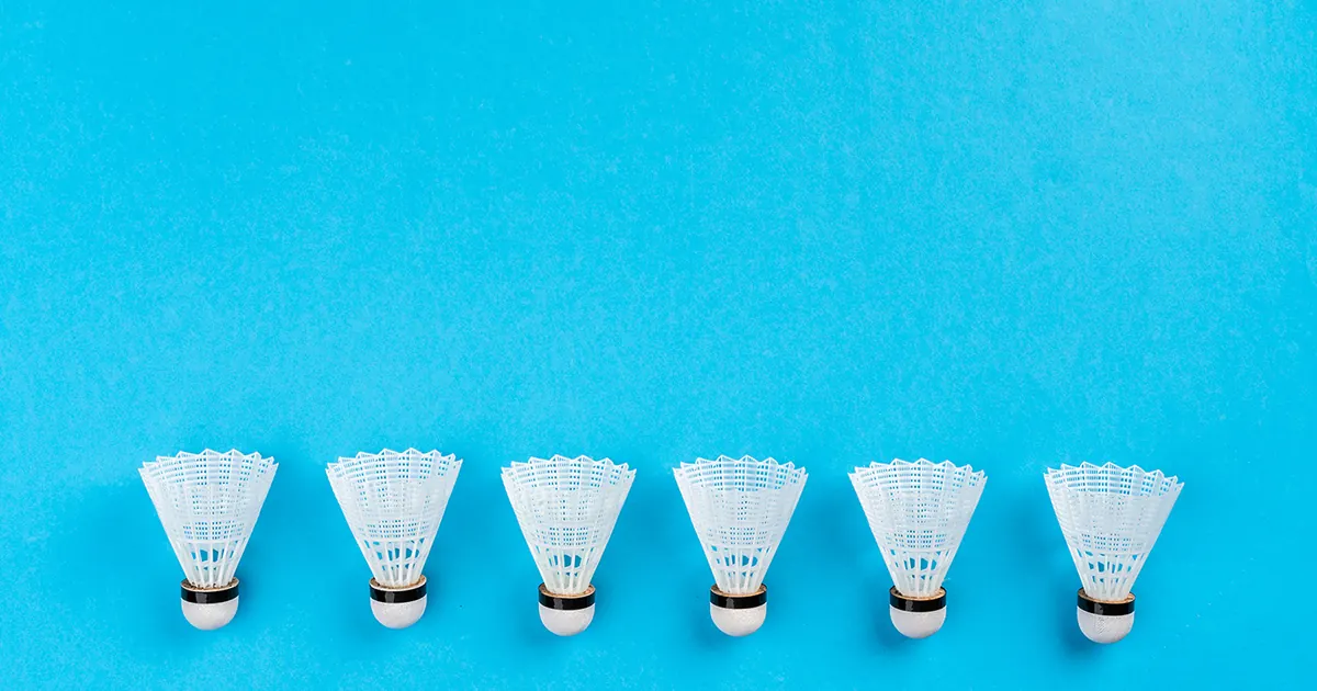 Six shuttlecocks in a row, pointing downward at the bottom of a bright blue background.